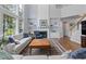 Bright living room features a fireplace, built-in shelving, large windows, and a staircase at 8106 Sommerwell St, Raleigh, NC 27613