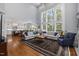 Bright living room with vaulted ceilings, large windows, hardwood floors, and open concept design to kitchen at 8106 Sommerwell St, Raleigh, NC 27613