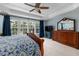Bright main bedroom featuring a coffered ceiling, ceiling fan, and multiple windows at 8106 Sommerwell St, Raleigh, NC 27613