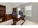 This office features a large wooden desk, shelving and windows creating a comfortable and productive workspace at 8106 Sommerwell St, Raleigh, NC 27613