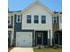 Charming townhome with blue siding, white accents, and a one-car garage under a clear blue sky at 817 Kensley Grove Ln # 16, Fuquay Varina, NC 27526