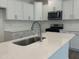 Kitchen island with stainless steel sink and faucet and white quartz countertop at 817 Kensley Grove Ln # 16, Fuquay Varina, NC 27526