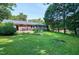 Large backyard with a well-maintained lawn and various trees and bushes at 827 Union St, Cary, NC 27511