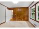 Bedroom featuring wood paneled wall, neutral carpet, and a view to the backyard at 827 Union St, Cary, NC 27511