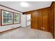 Bedroom featuring wood paneled wall, neutral carpet, and a view to the kitchen at 827 Union St, Cary, NC 27511