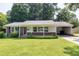 Charming single-story brick home featuring a well-manicured lawn and covered carport on a sunny day at 827 Union St, Cary, NC 27511