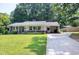 Charming single-story brick home featuring a well-manicured lawn and covered carport with long driveway at 827 Union St, Cary, NC 27511