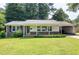 Charming single-story brick home featuring a well-manicured lawn and covered carport on a sunny day at 827 Union St, Cary, NC 27511