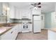 Bright eat-in kitchen features white appliances, ample cabinet space and a ceiling fan at 827 Union St, Cary, NC 27511