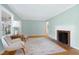 Bright living room featuring a decorative fireplace, hardwood floors, neutral paint, and large windows at 827 Union St, Cary, NC 27511