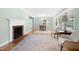 Bright living room featuring a decorative fireplace, hardwood floors, neutral paint, and dining room area at 827 Union St, Cary, NC 27511