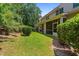 A lush backyard featuring a well-maintained lawn, mature trees, and a screened in porch at 927 Contessa Dr, Cary, NC 27513