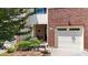 Close-up of townhome entrance featuring a single-car garage, garden bed, and covered porch at 927 Contessa Dr, Cary, NC 27513