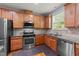 Well-equipped kitchen featuring stainless steel appliances, stone counters, and wood cabinets at 927 Contessa Dr, Cary, NC 27513