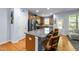 Modern kitchen boasts stainless steel appliances, an island with bar seating, and hardwood flooring at 927 Contessa Dr, Cary, NC 27513