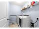 Bright laundry room with modern washer, dryer, storage shelves, and convenient access at 927 Contessa Dr, Cary, NC 27513