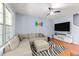 Comfortable living room area with an L-shaped sofa, ceiling fan, TV and natural light at 927 Contessa Dr, Cary, NC 27513