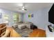Comfortable living room area with a zebra rug, L-shaped sofa, fan and natural light at 927 Contessa Dr, Cary, NC 27513