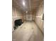 Unfinished garage with a partially open door and green trash bins at 0416 Hazy Hls Ln, Garner, NC 27529