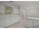 Bright kitchen featuring white cabinets, tile flooring, and natural light from the window at 100 Edenburgh Rd # 202, Raleigh, NC 27608