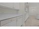 View of the white kitchen cabinets and countertops, adjacent to a dining area at 100 Edenburgh Rd # 202, Raleigh, NC 27608