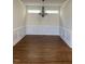 Dining room featuring elegant chandelier, wainscoting, and hardwood floors at 108 Bally Shannon Way, Apex, NC 27539