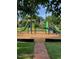 Community playground with various play structures, safe mulch ground cover, and a grassy area at 108 Bally Shannon Way, Apex, NC 27539