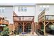 Backyard view of townhome decks and patios with outdoor trash cans at 110 Great Ridge Ct, Morrisville, NC 27560