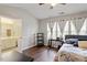 Light-filled bedroom with hardwood floors, ceiling fan, and ensuite bathroom at 110 Great Ridge Ct, Morrisville, NC 27560
