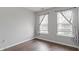 Empty bedroom showcasing wood floors, neutral walls, and two windows with patterned curtains at 110 Great Ridge Ct, Morrisville, NC 27560