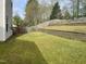 Grassy backyard featuring terraced landscaping, a wooden fence, and plenty of open space at 1126 Woodlands Creek Way, Apex, NC 27502