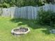 Backyard featuring a fire pit surrounded by a wooden fence and mature greenery at 1126 Woodlands Creek Way, Apex, NC 27502
