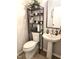 Cozy half bath with neutral walls, tile floors, and a toilet and pedestal sink combo at 1126 Woodlands Creek Way, Apex, NC 27502