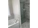 Bright bathroom featuring soaking tub and glass shower with elegant marble-like tile at 1126 Woodlands Creek Way, Apex, NC 27502