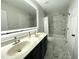 Bathroom with double sink vanity, modern lighting, shower/tub and marble-like tile floors at 1126 Woodlands Creek Way, Apex, NC 27502