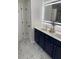 Bathroom with double sink vanity, modern lighting, stylish fixtures, and marble-like tile floors at 1126 Woodlands Creek Way, Apex, NC 27502