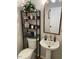 Modern bathroom featuring pedestal sink, mirror, and toilet with storage shelf at 1126 Woodlands Creek Way, Apex, NC 27502