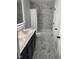 Bathroom with double sink vanity, modern lighting, shower/tub and marble-like tile floors at 1126 Woodlands Creek Way, Apex, NC 27502