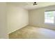 A well-lit room with carpet, a ceiling light, and a window at 1126 Woodlands Creek Way, Apex, NC 27502