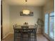 Bright dining area with a wooden table set for six, modern light fixture, and access to the outdoors at 1126 Woodlands Creek Way, Apex, NC 27502