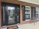 Charming front porch featuring brick accents, a storm door, and bench seating at 1126 Woodlands Creek Way, Apex, NC 27502