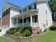 Charming two-story home featuring a welcoming covered porch and beautifully landscaped flower beds at 1126 Woodlands Creek Way, Apex, NC 27502