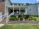 Charming front porch with white columns and railing overlooking a beautiful stone flower bed at 1126 Woodlands Creek Way, Apex, NC 27502