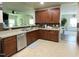 Open kitchen with stainless steel appliances, granite countertops, rich wood cabinets, and bar seating at 1126 Woodlands Creek Way, Apex, NC 27502