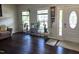 Bright living room featuring dark wood floors, lots of plants, and a white front door at 1126 Woodlands Creek Way, Apex, NC 27502