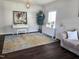 Bright living room features a white piano and cabinet, and neutral walls and dark floors at 1126 Woodlands Creek Way, Apex, NC 27502