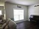 Sitting room with dark wood floors, neutral walls, a piano, and natural light from the window at 1126 Woodlands Creek Way, Apex, NC 27502