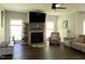 Inviting living room featuring a stone fireplace, large windows, comfortable seating, and a ceiling fan at 1126 Woodlands Creek Way, Apex, NC 27502