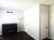 Sitting room featuring a dark wood floor, neutral walls, a piano, and three white paneled doors at 1126 Woodlands Creek Way, Apex, NC 27502