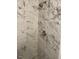 Close-up of the shower featuring gray, marbled tile and chrome fixtures at 1126 Woodlands Creek Way, Apex, NC 27502